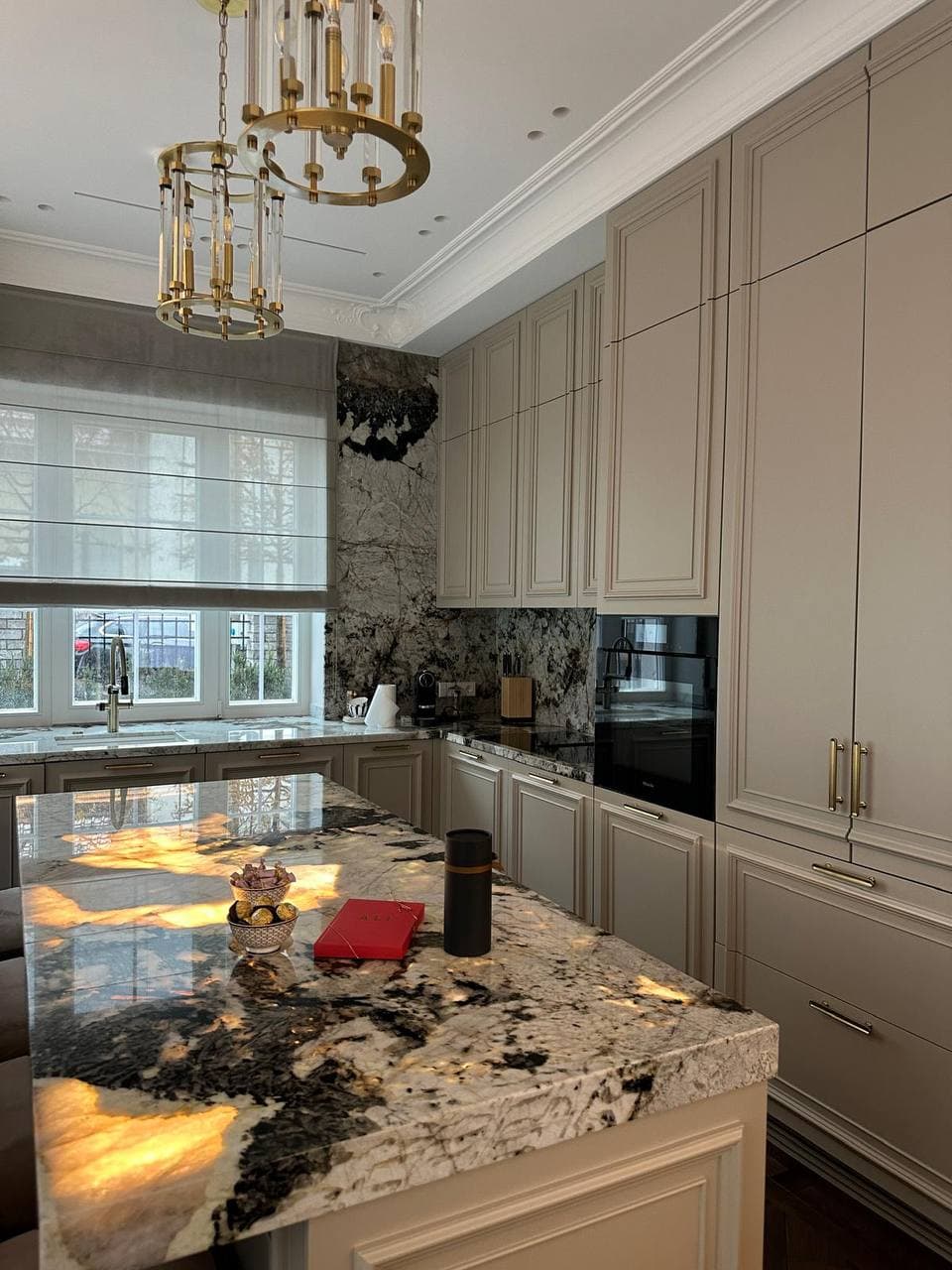 Contemporary kitchen with marble surfaces and refined material detailing